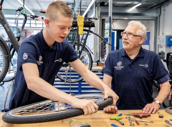 Jonge en oude fietsenmaker aan het werk