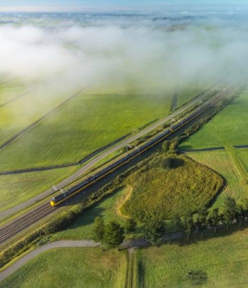 trein rijdt door groen nederlands landschap